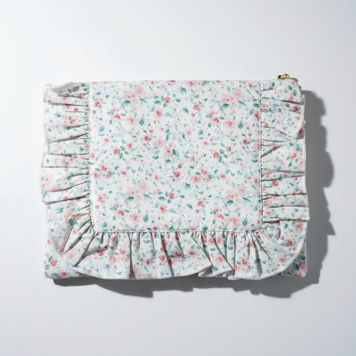 Pastel floral zip pouch with ruffle trim, gathered sides, and top zipper seam
