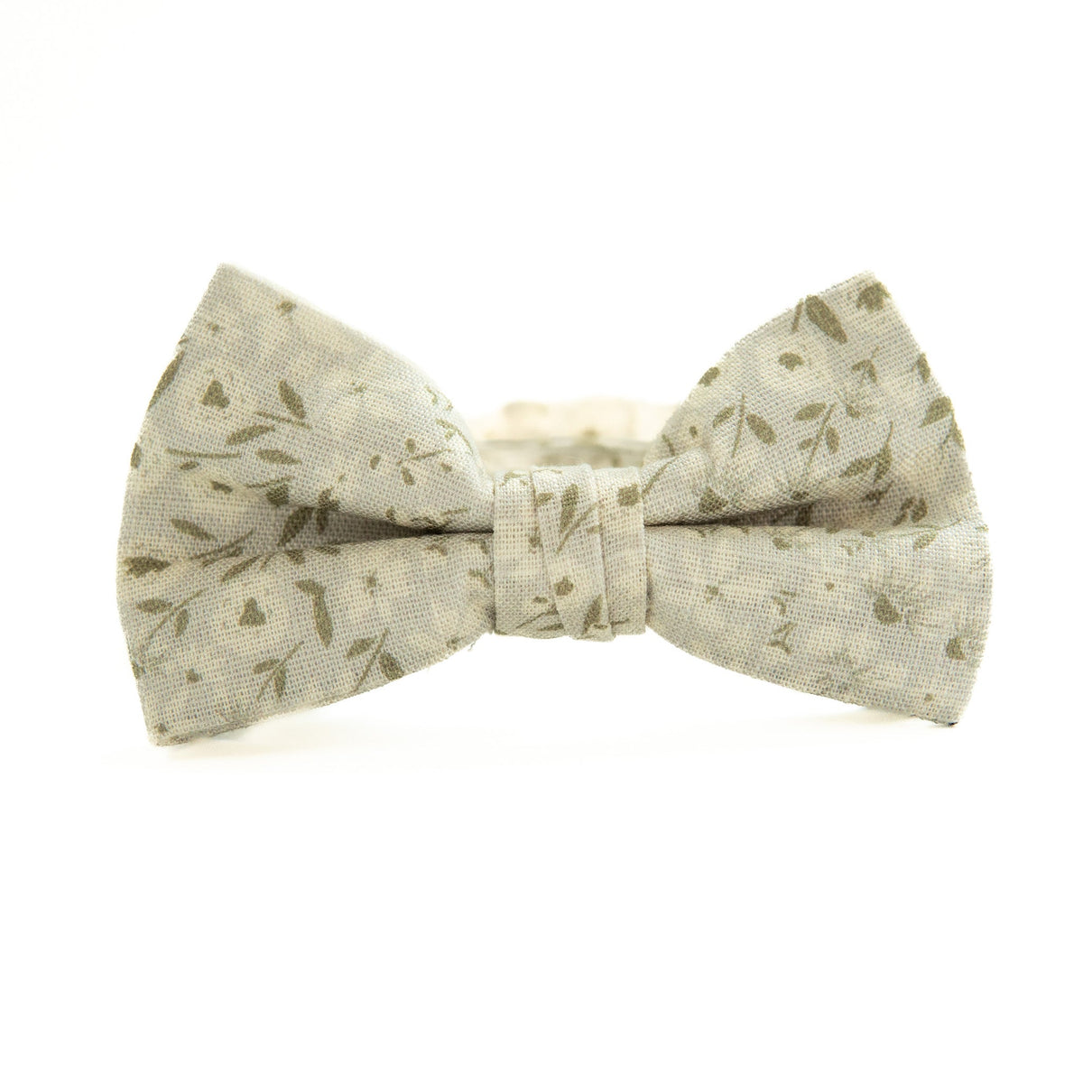 Boys bow tie with light cream fabric and green leaf pattern, tied bow