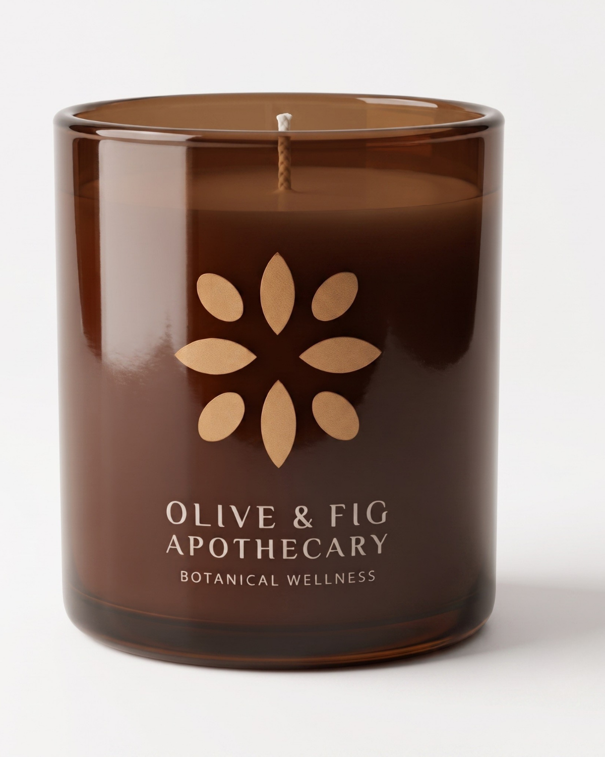 Unlit amber glass candle with botanical flower emblem and Olive & Fig Apothecary label