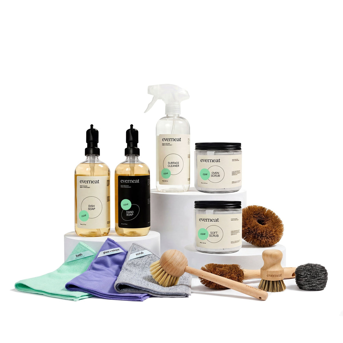 Full kitchen cleaning assortment with bottles, jars, cloths, and scrub brushes