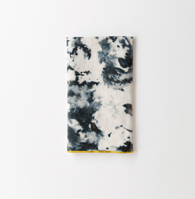 Marble print napkin with dark blue-gray pattern and yellow trim edge
