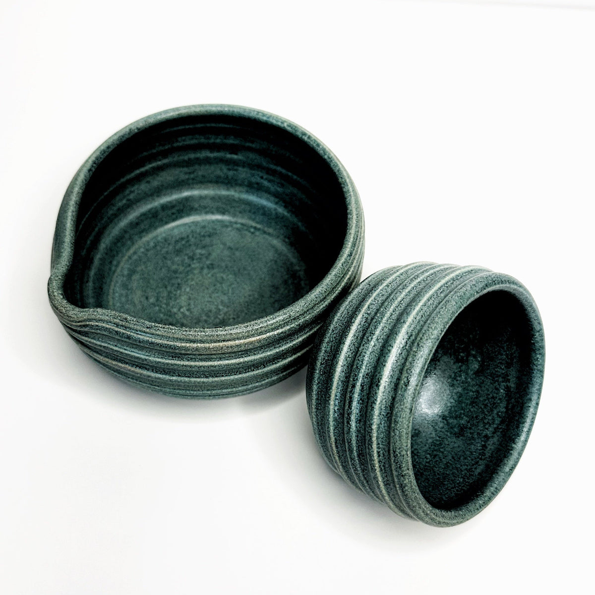 Forest green ceramic matcha bowls set with open mini cup, textured stone-glazed finish.