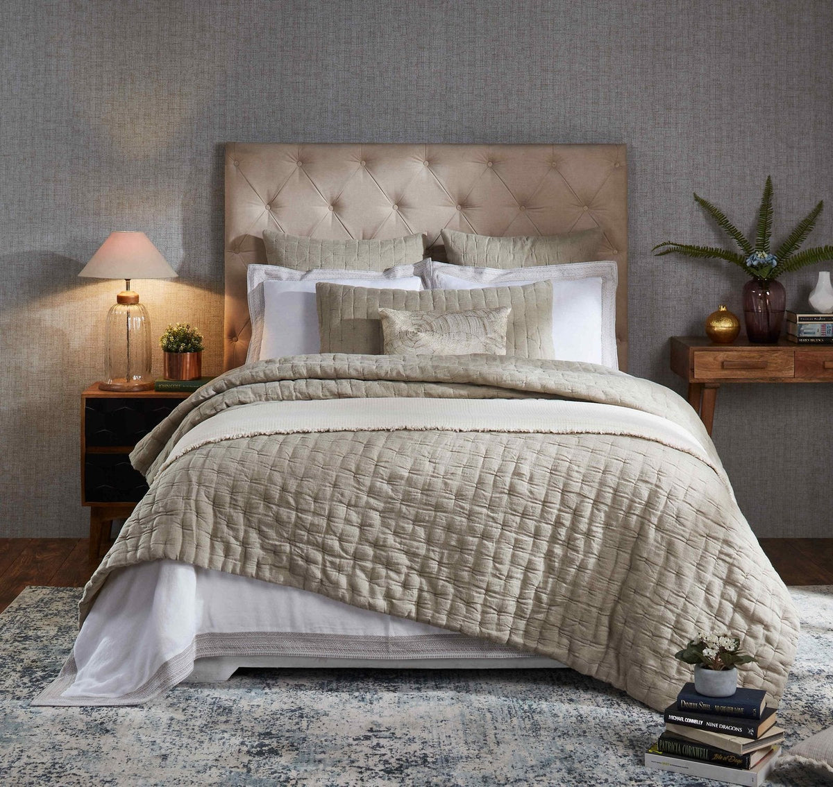 Light beige linen quilt on bed, hand-pinched quilting texture visible.
