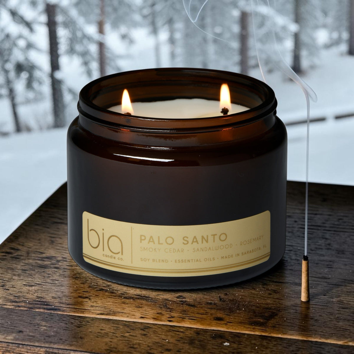 Dark glass soy candle jar with lit flame and cream label reading Palo Santo