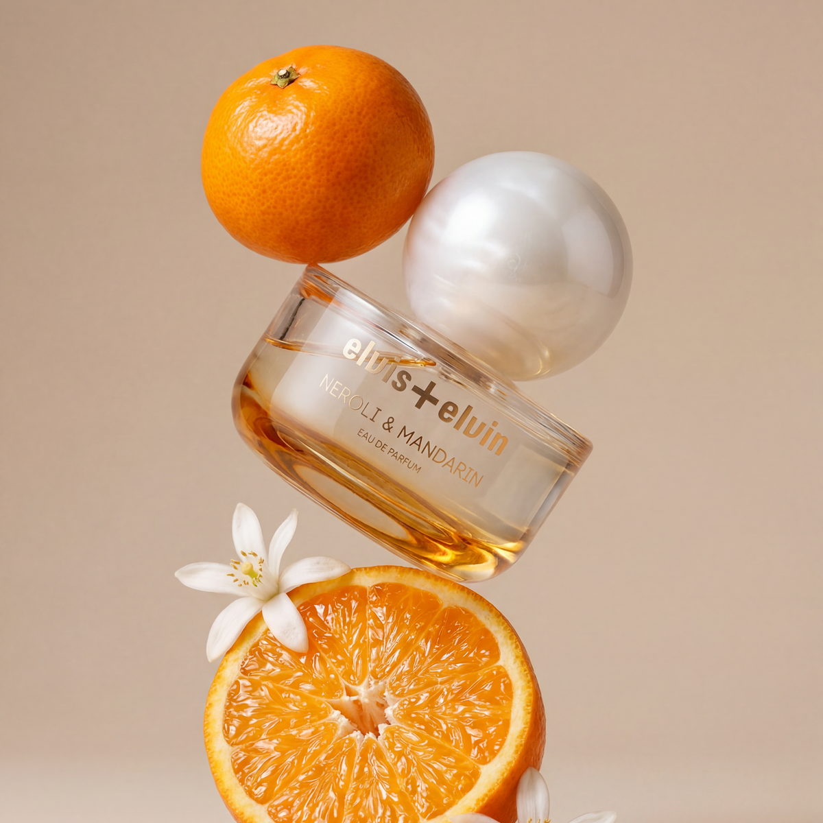 Eau de parfum bottle with round glass cap, amber liquid, and mandarin and flower