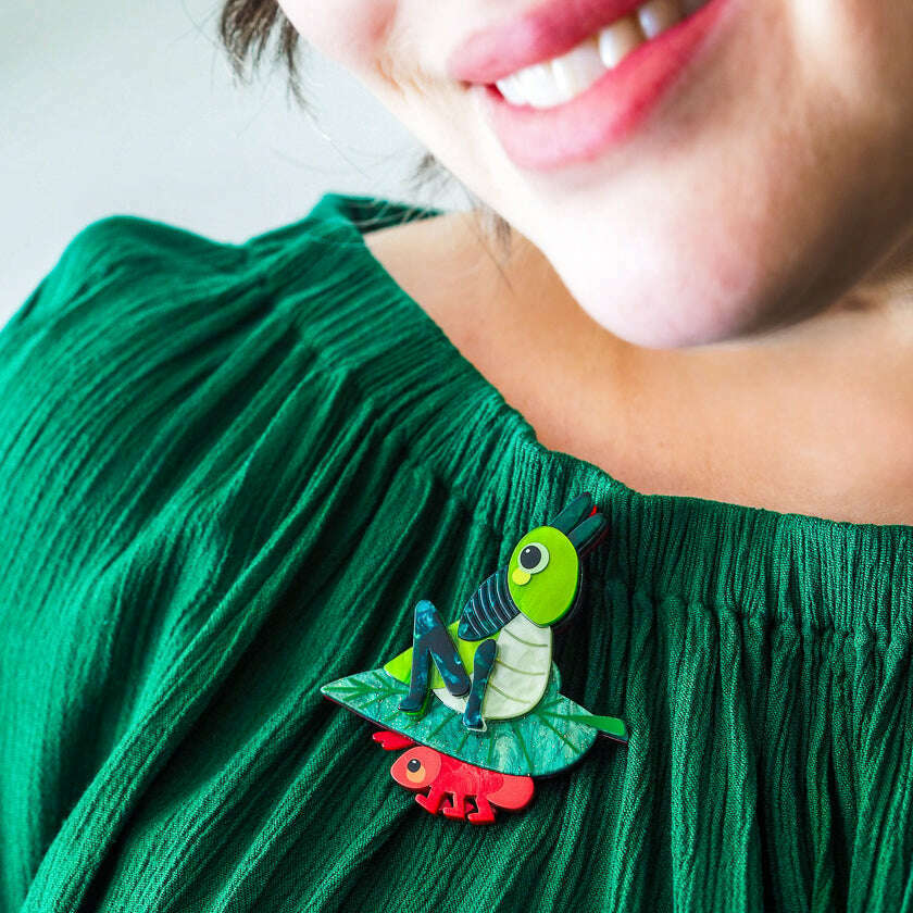 Meal prep brooch on green dress: green rabbit design with red feet