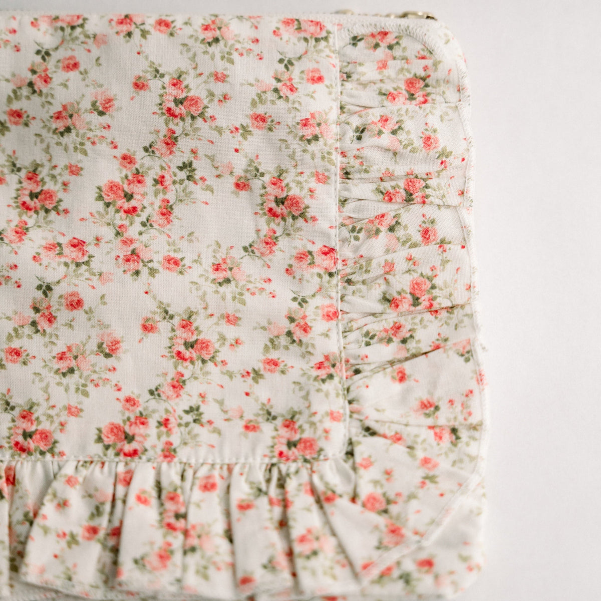 White floral ruffle zip pouch close-up of pleats and zipper track