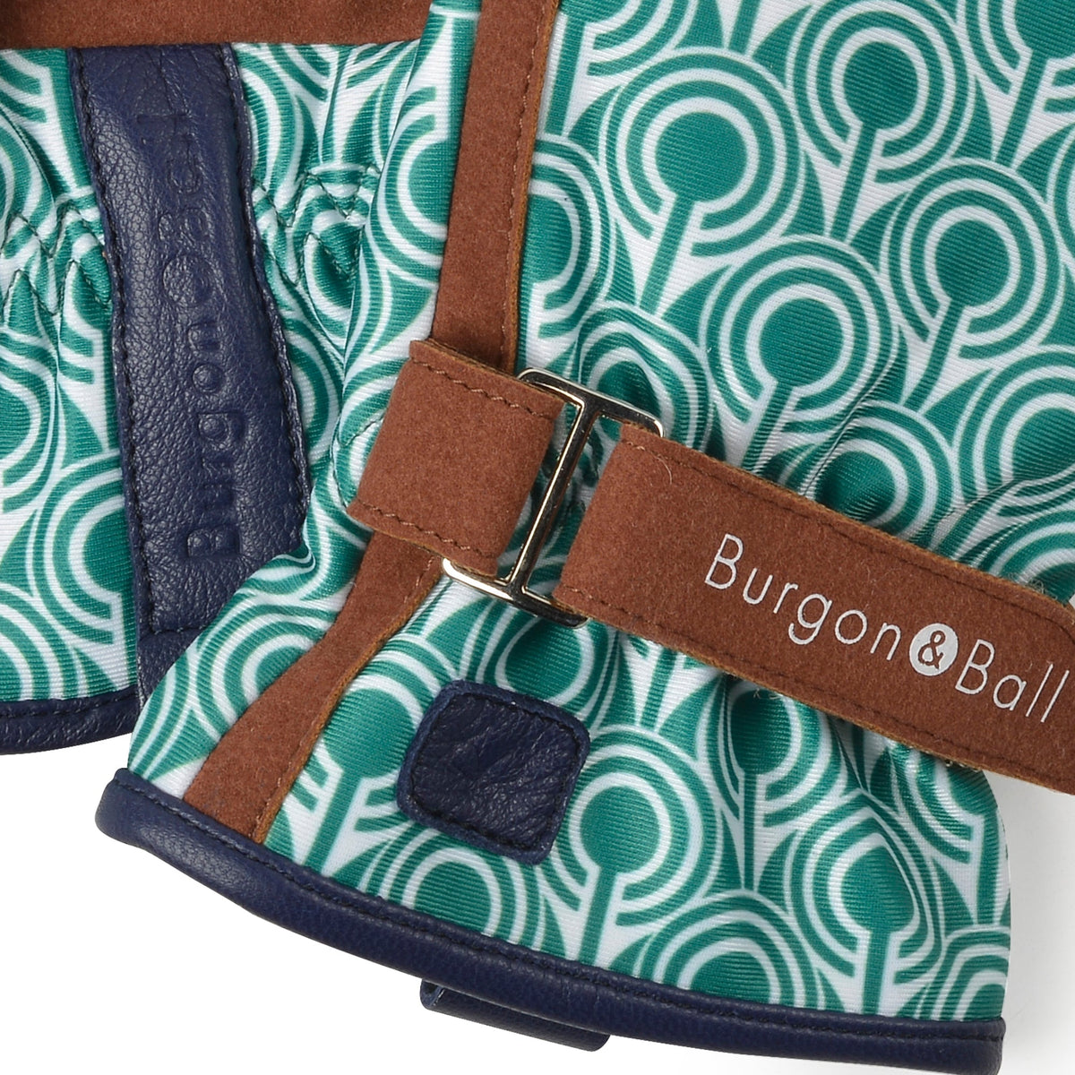 Close-up of teal patterned garden glove with brown wrist strap and buckle