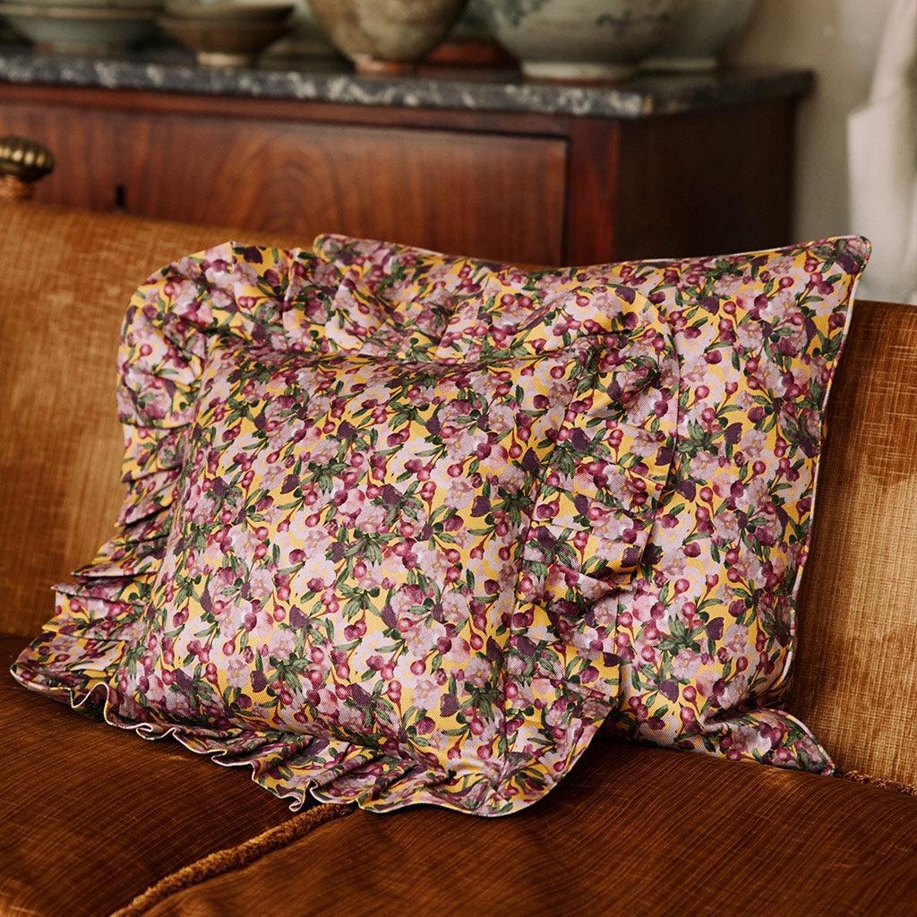 Yellow floral ruffled pillow cover with buttonless envelope back and gathered ruffles