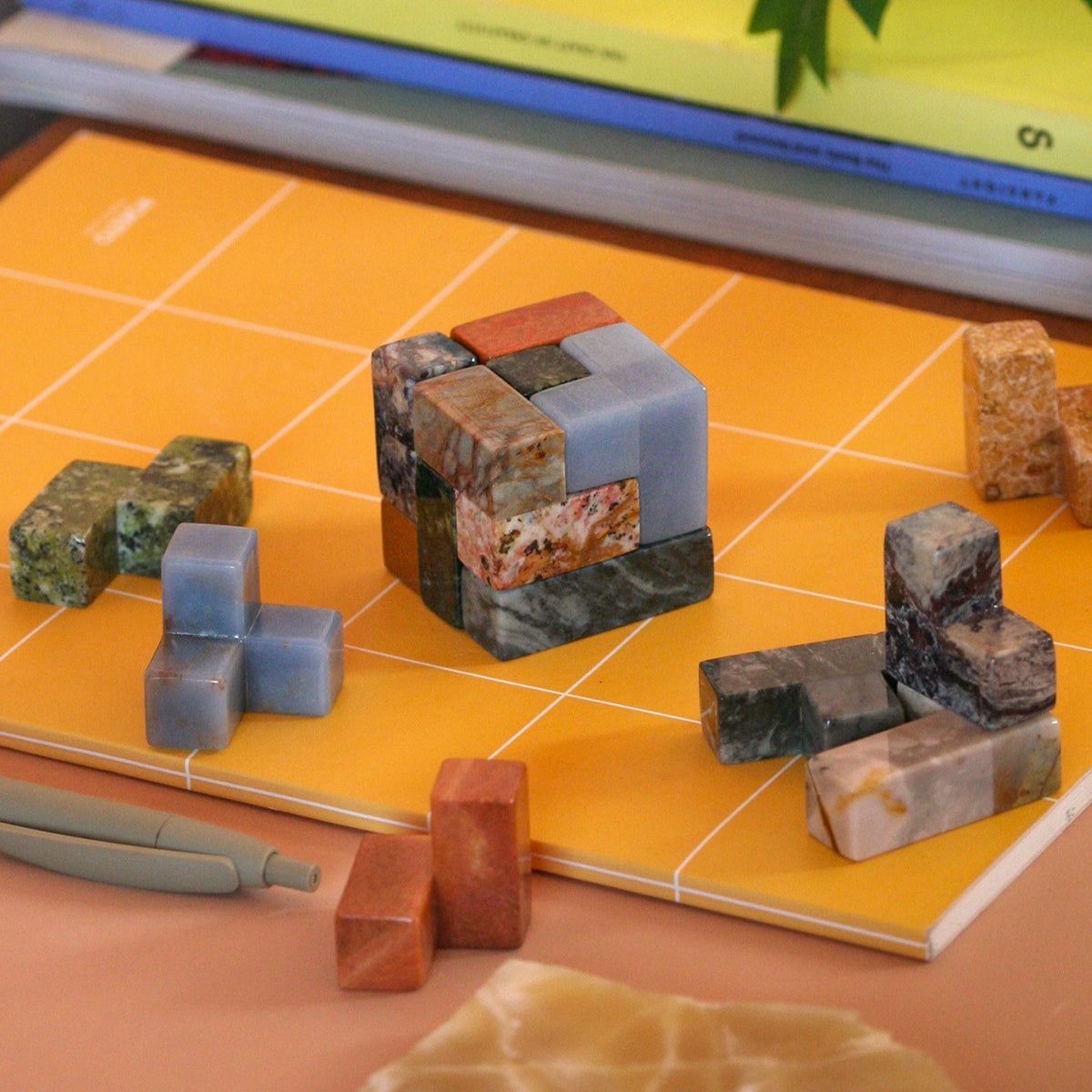 Gemstone cube puzzle centered on an orange board, surrounded by matching stone pieces.