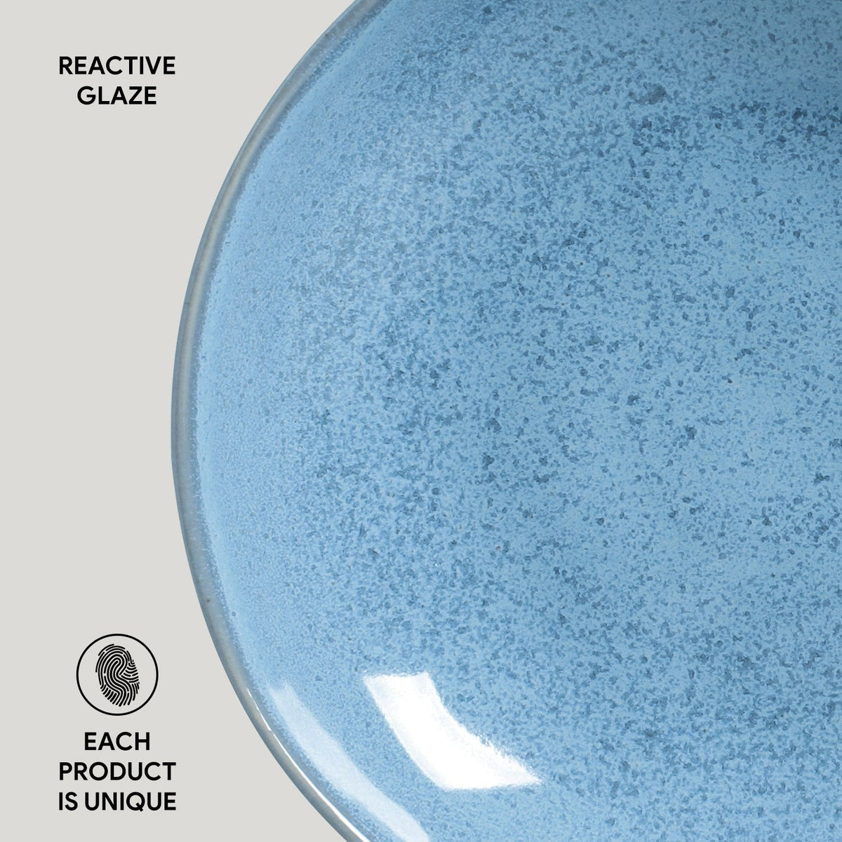 Blue reactive-glaze pasta plate, speckled round shallow bowl close-up.