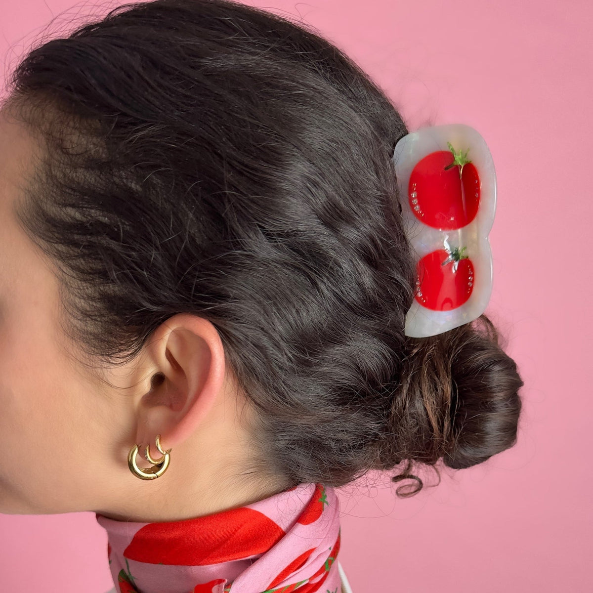Tomato-themed hair claw clip holding a low bun; red tomato design with green stems