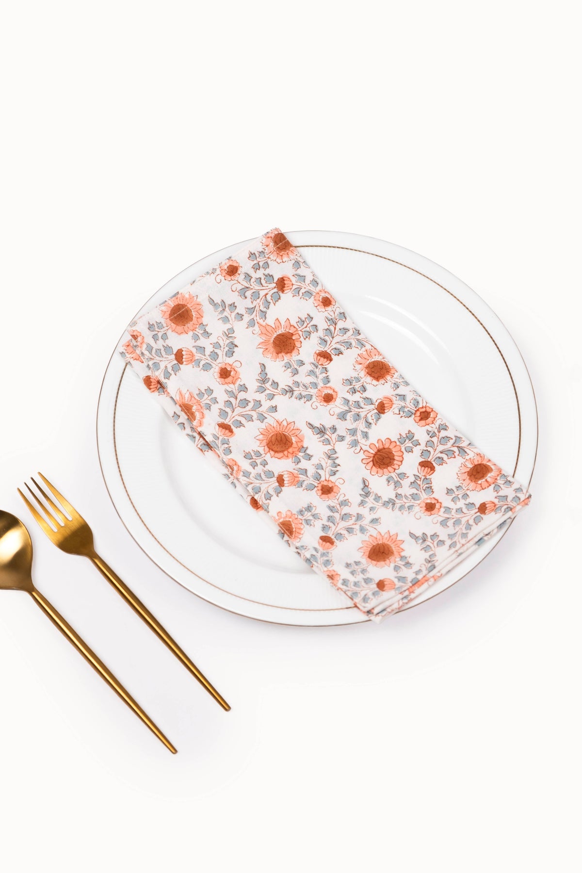 Floral block-printed napkin, folded; terracotta and white print
