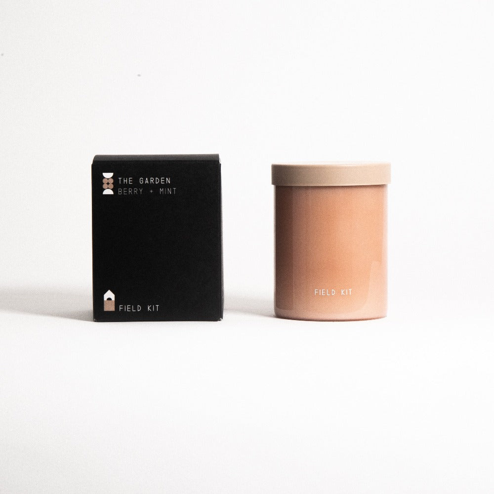 Candle jar and black gift box labeled "Field Kit" and "The Garden Berry: Mint".