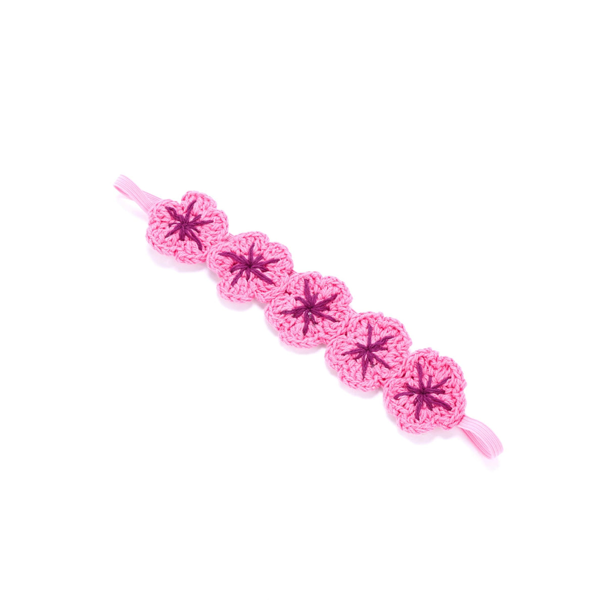 Bright pink knit flower crown headband with dark centers and elastic ends