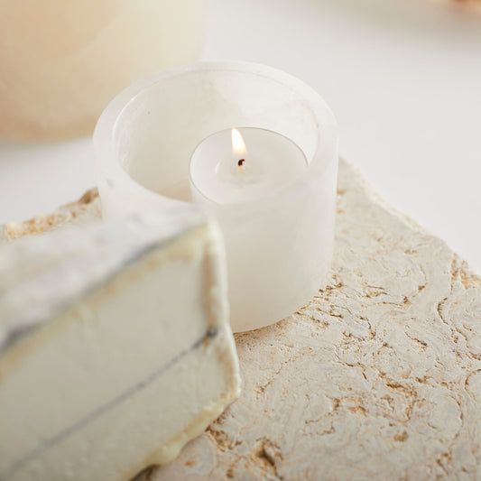 Santo alabaster footed bowl with lit candle, frosted white finish
