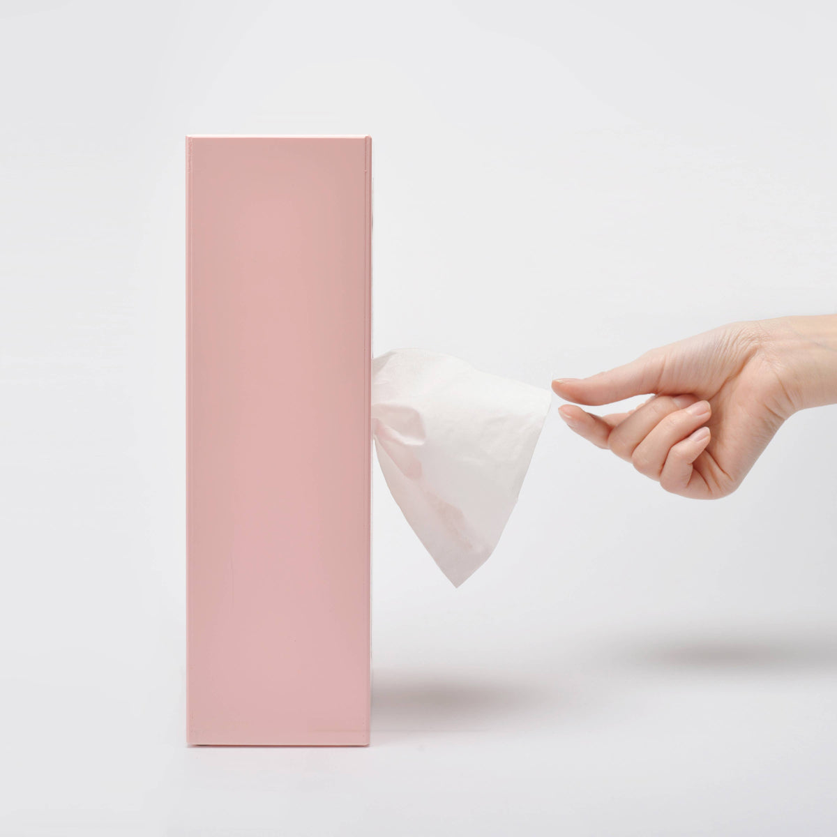 Pink tissue box cover with tissue being pulled out by hand