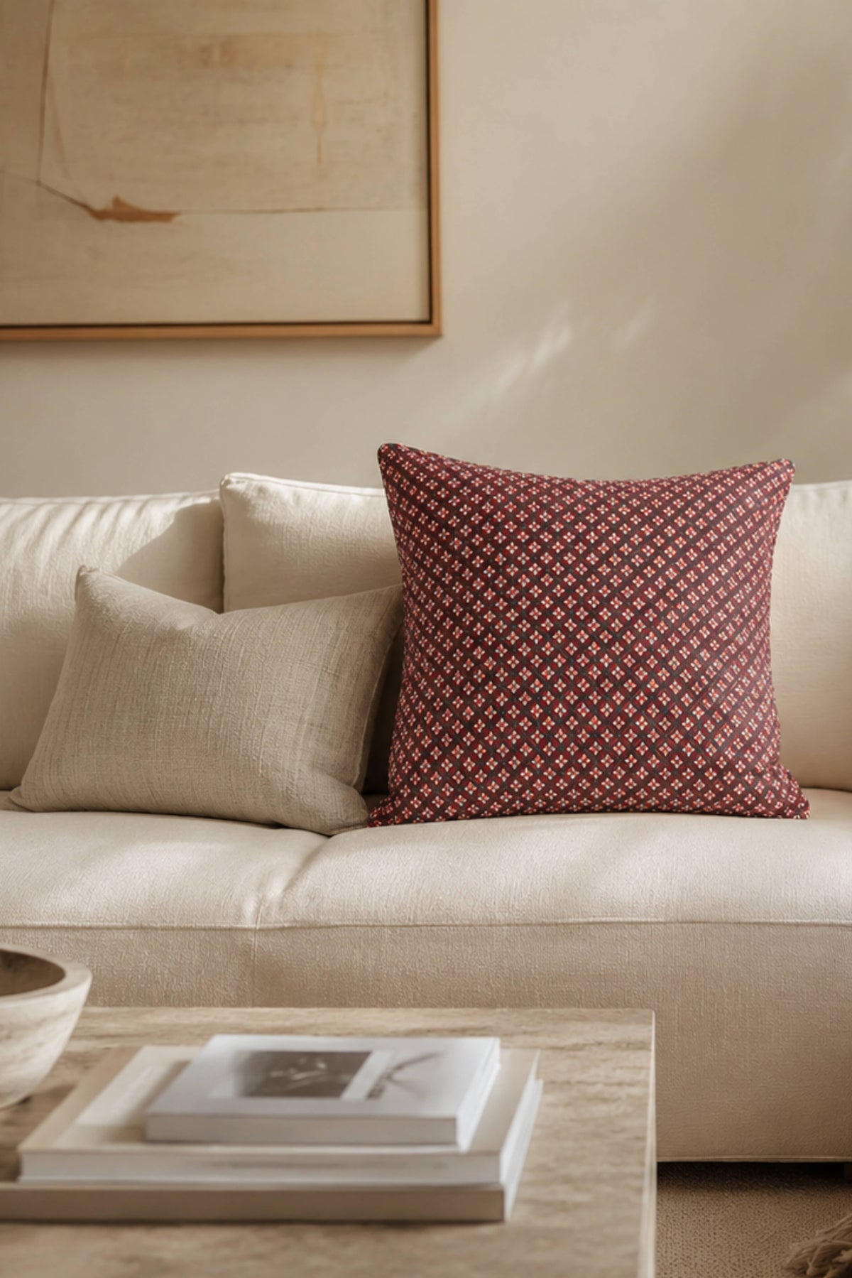 Crimson diamond-pattern pillow cover with dark piping on sofa