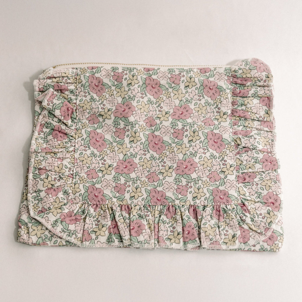 Floral print zipper pouch with ruffled bottom edge and pink zipper pull.