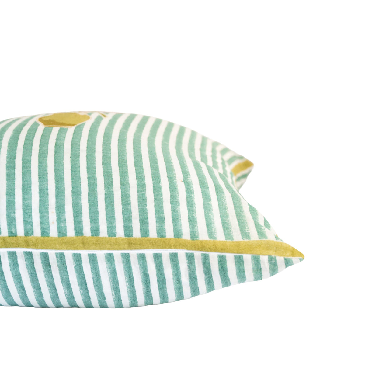 Close-up side view of green striped pillow with yellow piping along the seam