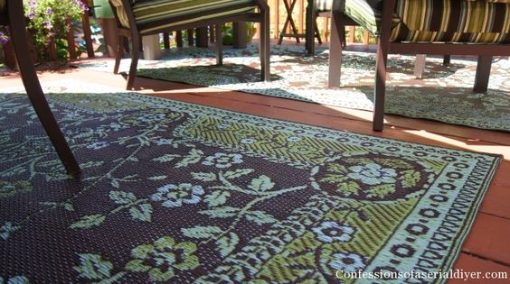 Teal and brown floral patterned outdoor mat with decorative border, angled view