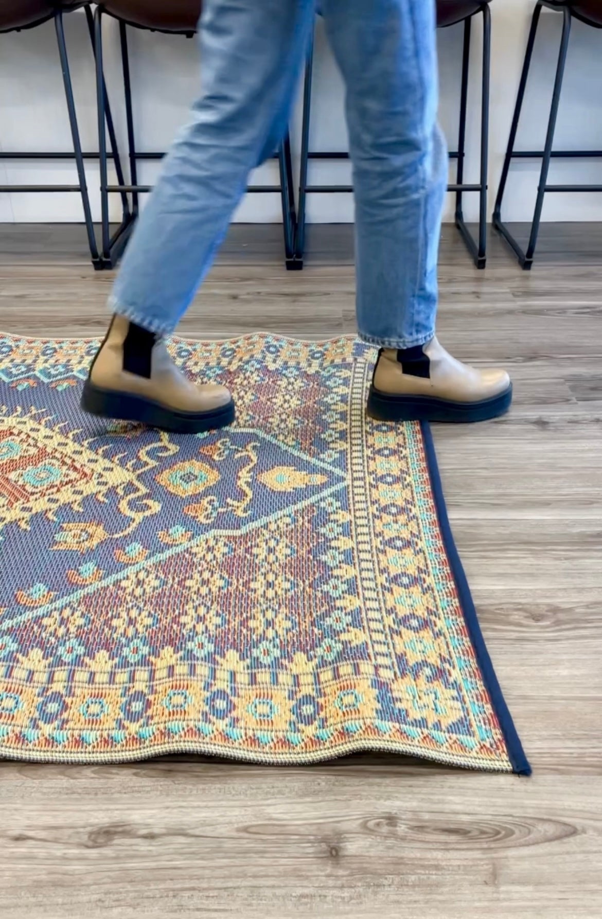 Turkish-style area rug corner with blue, orange, and cream border pattern