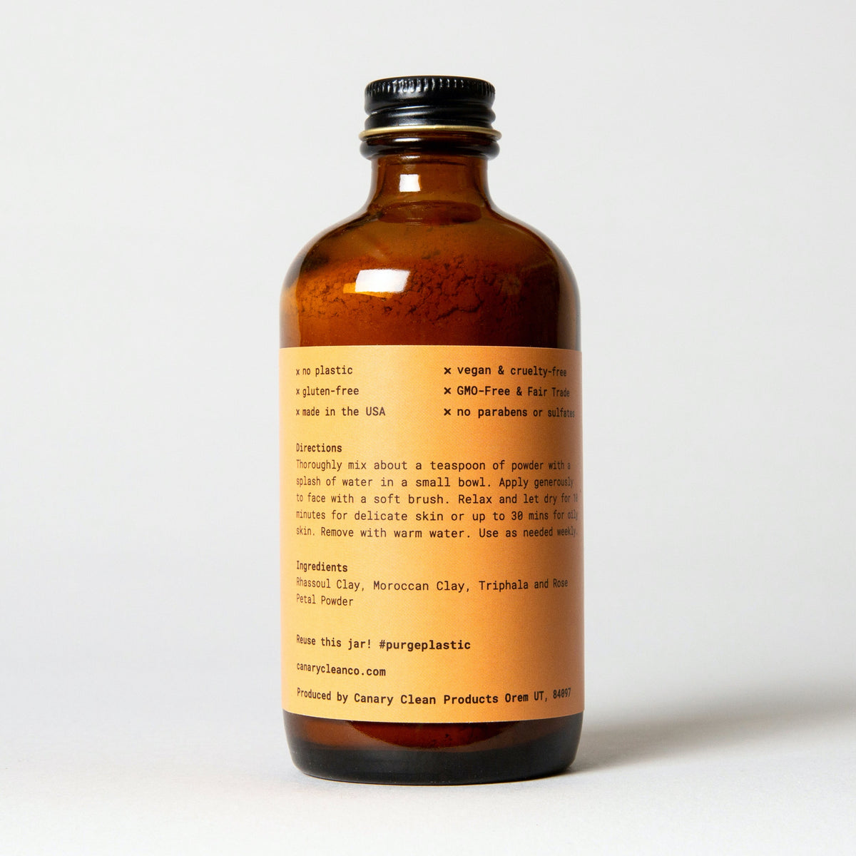 Amber bottle of Rhassoul clay and rose face mask, showing the ingredient label