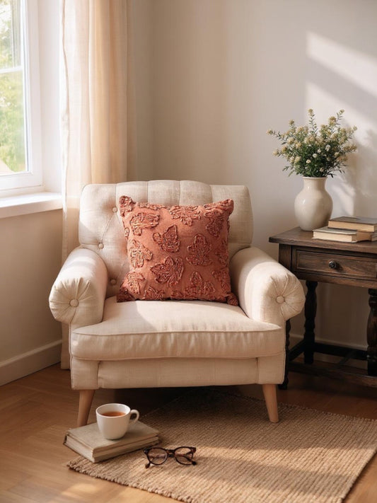 Square throw pillow with rust-orange embroidered leaf design