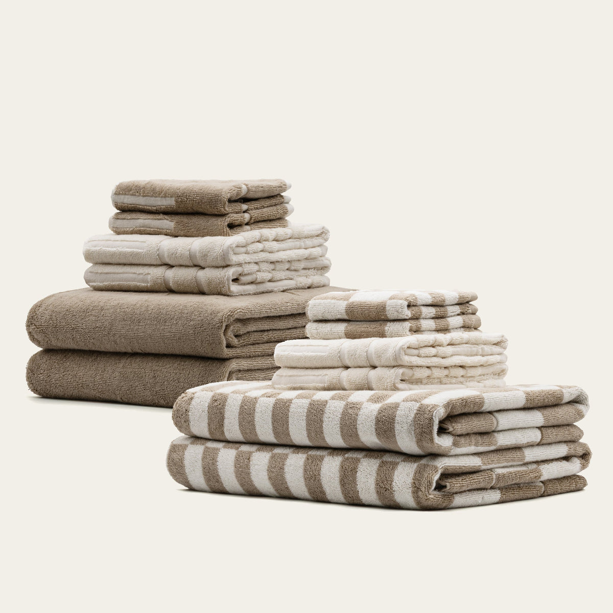 Stacked cotton towels in tan, ecru, and striped checks