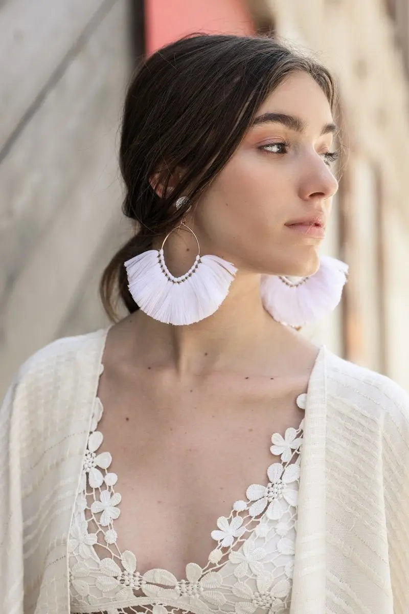 White fan tassel earrings with fringe layers and gold-tone loop backing