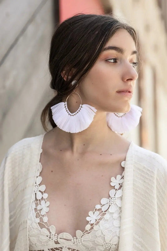 White fan tassel earrings with fringe layers and gold-tone loop backing
