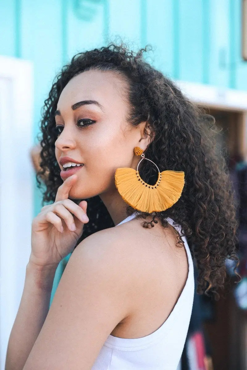 Mustard yellow fan tassel drop earrings with scalloped fringe and gold-tone hoops