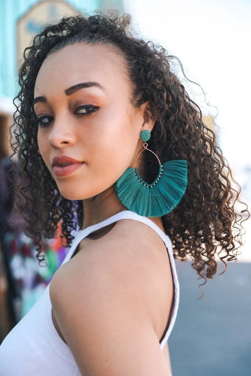 Teal fan tassel earrings with rounded fringe fan and gold-tone hoop details