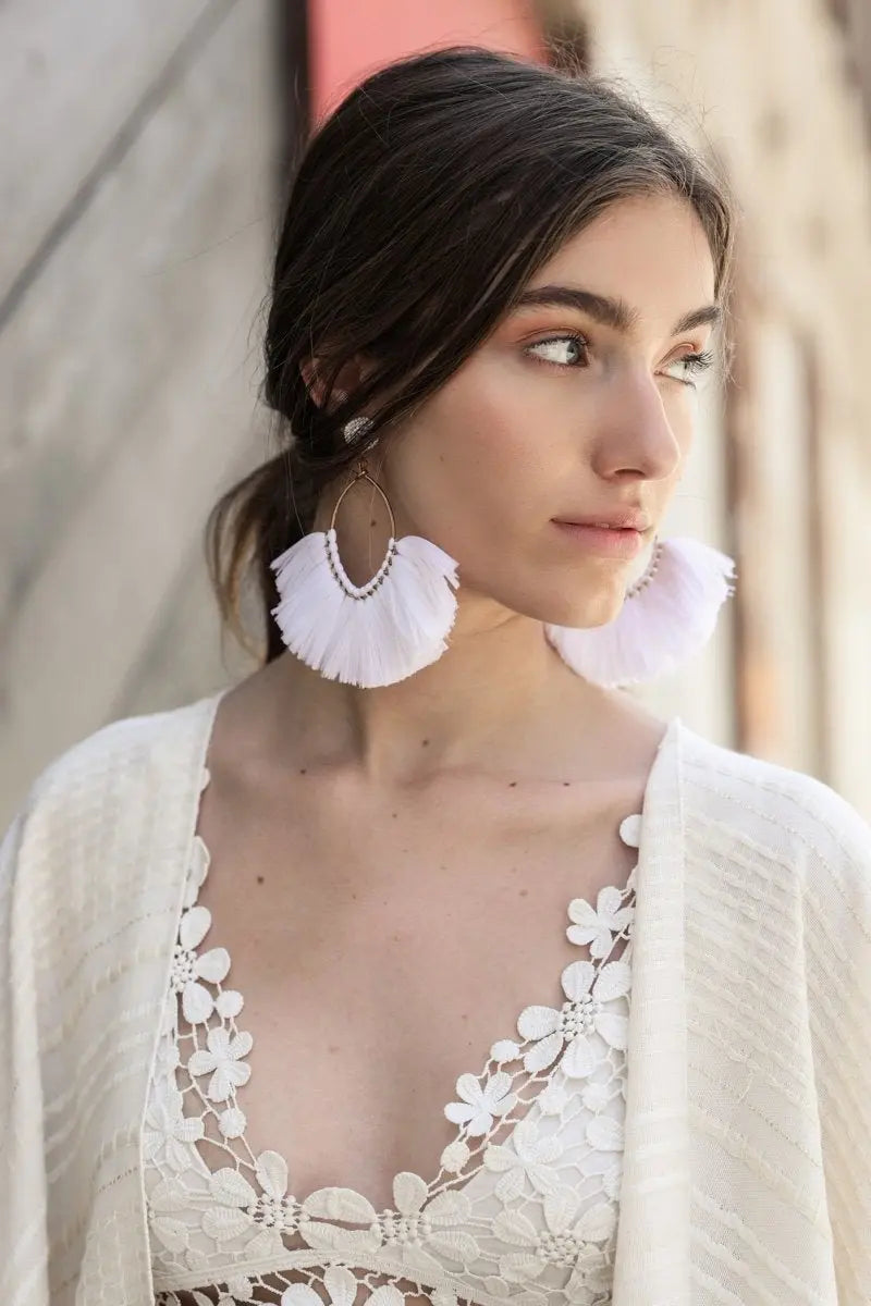 White fan tassel drop earrings with layered fringe and gold-tone hoop detail