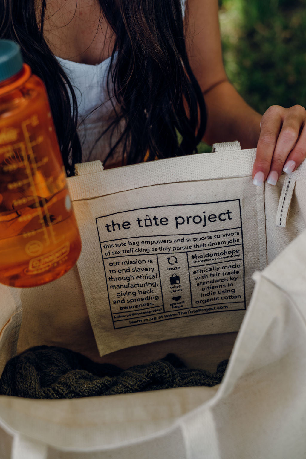 Canvas tote bag with printed label insert, open top close-up