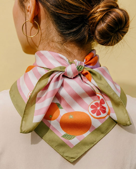 Cotton-silk bandana worn at neck, tied bow; pink striped citrus print with green edge