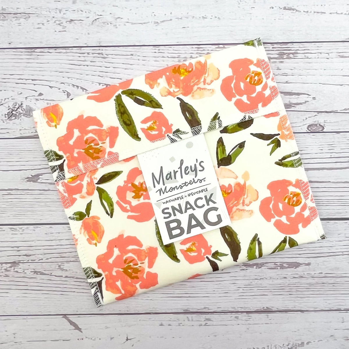 Reusable snack bag with peach flower print and green leaf accents, stitched border