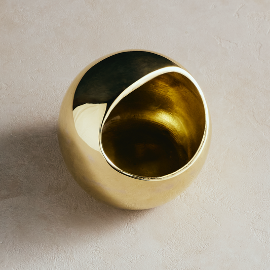 Gold salt cellar bowl with dark inner lining and curved rim