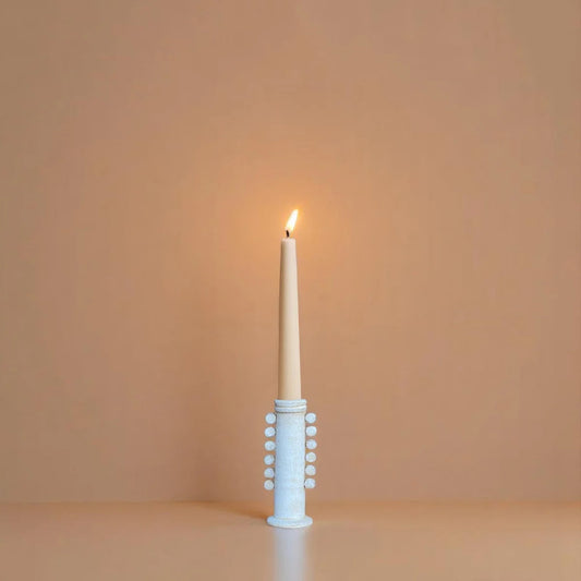Celia candle holder with light blue dotted sleeve holding a white pillar candle