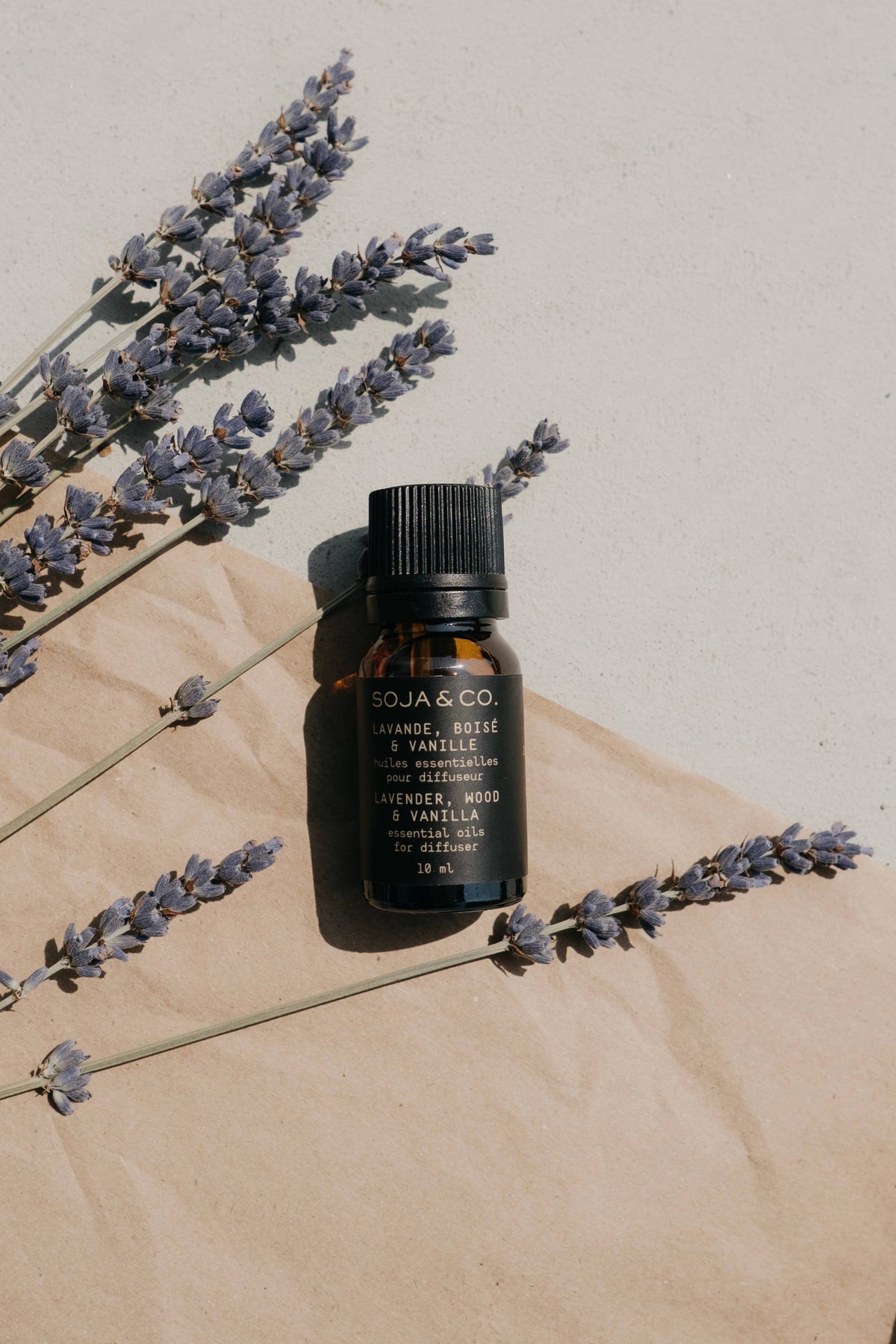 Essential oil bottle with lavender sprigs, amber glass and black cap (SOJA & CO.)