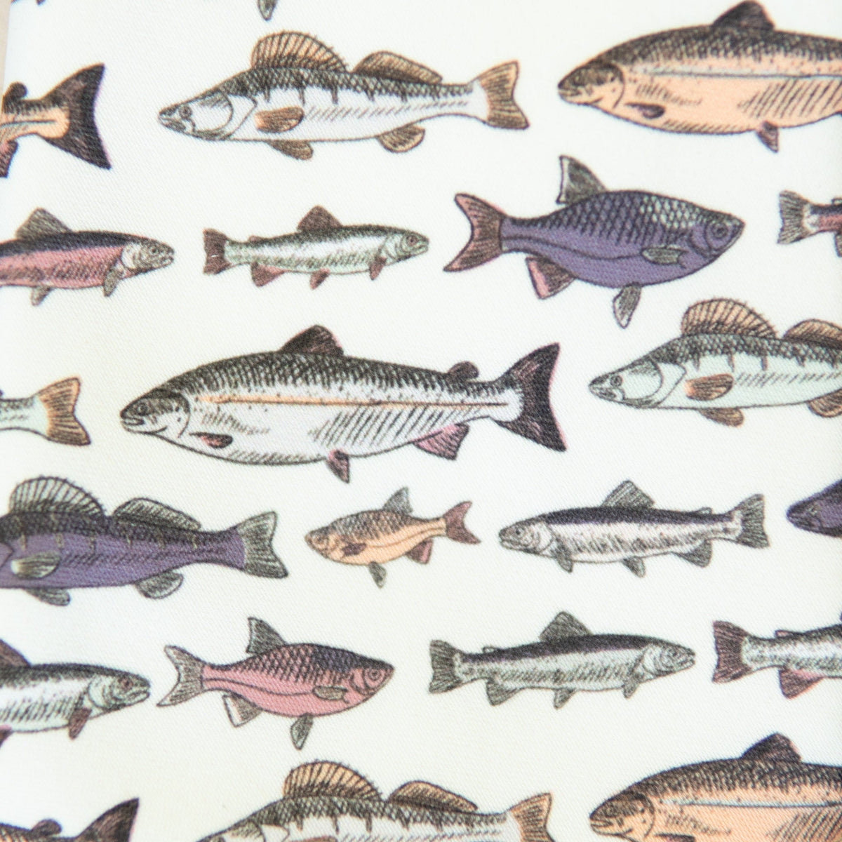 Close-up of white necktie fabric with multicolor fish pattern