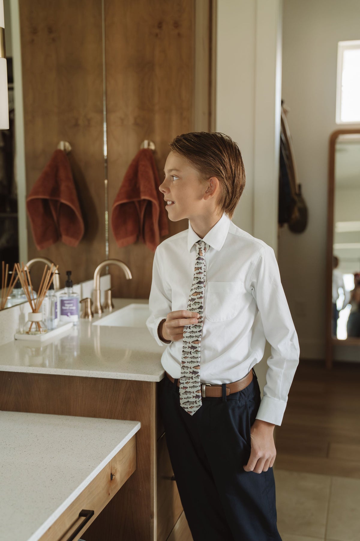 Youth boy wearing a white dress shirt with a fish-print necktie