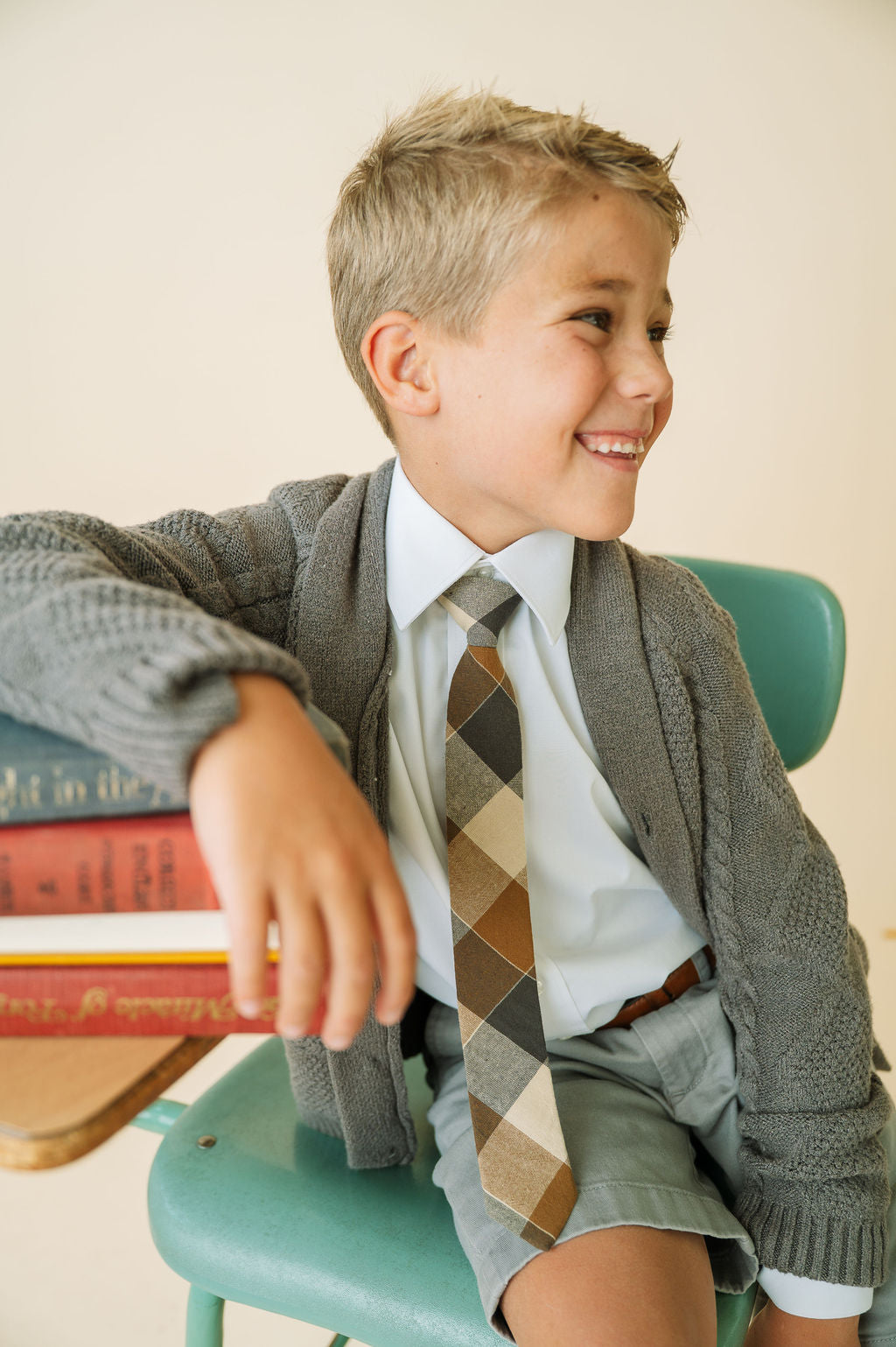 Boys necktie with tan, gray, and black argyle pattern worn with a shirt