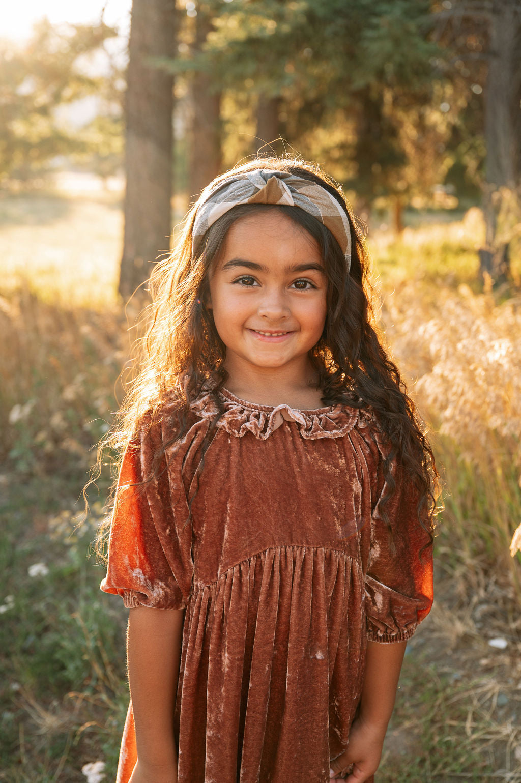 Plaid knotted headband worn on hair, tan and charcoal tones with bow knot