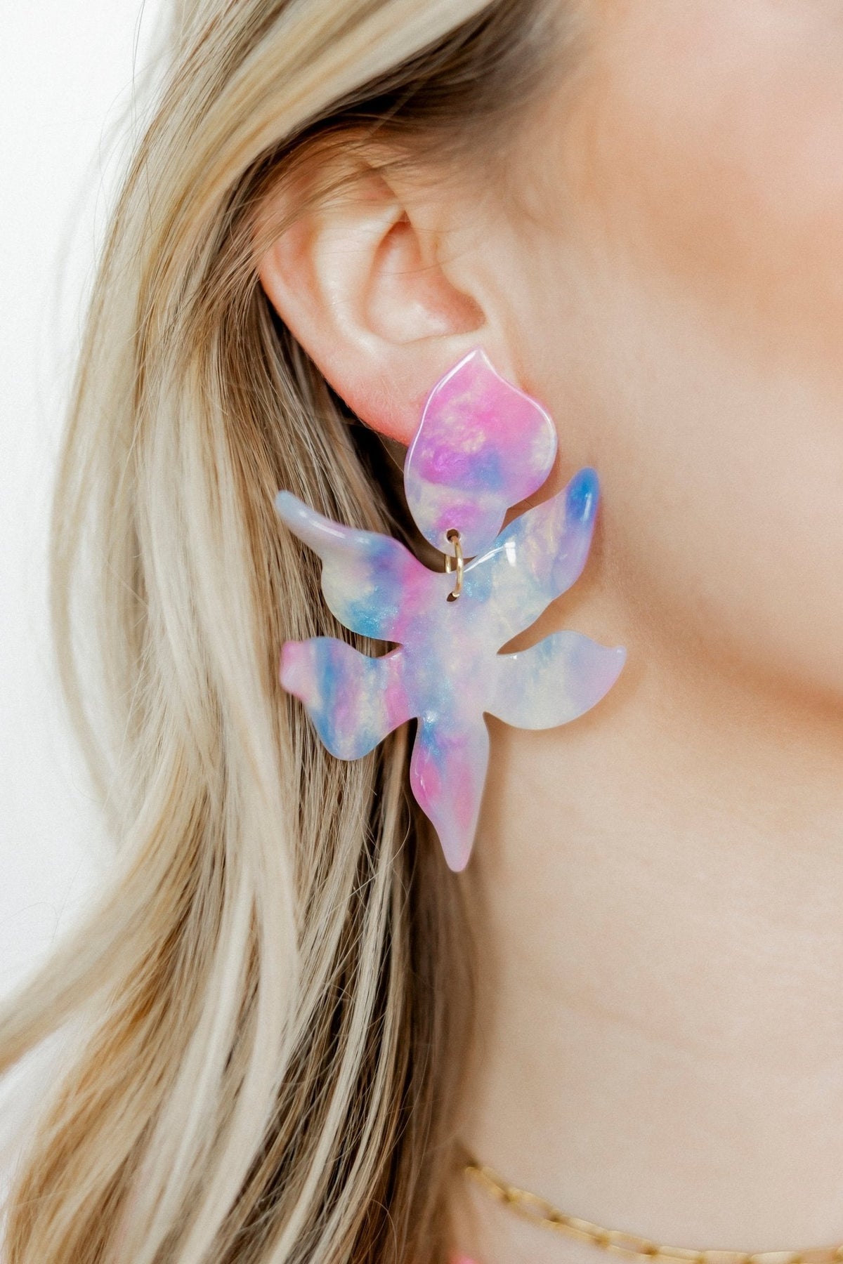Cotton-candy watercolor flower earrings with gold-tone hook, worn on ear
