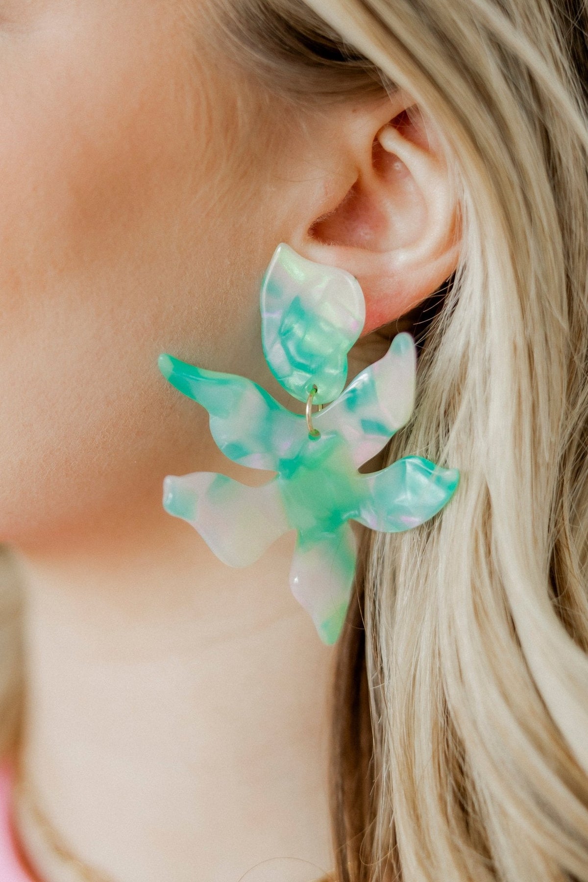 Teal seaglass floral earrings in translucent petal design, worn on ear
