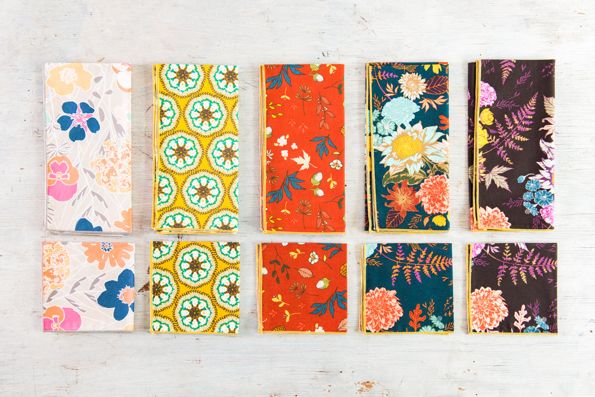 Floral cloth napkin set with colorful swatch patterns in blue, orange, and pink