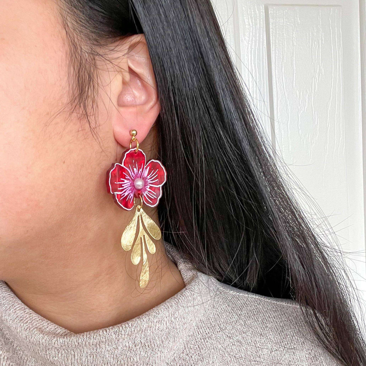 Red acrylic flower drop earrings with pearl centers and gold leaf accents