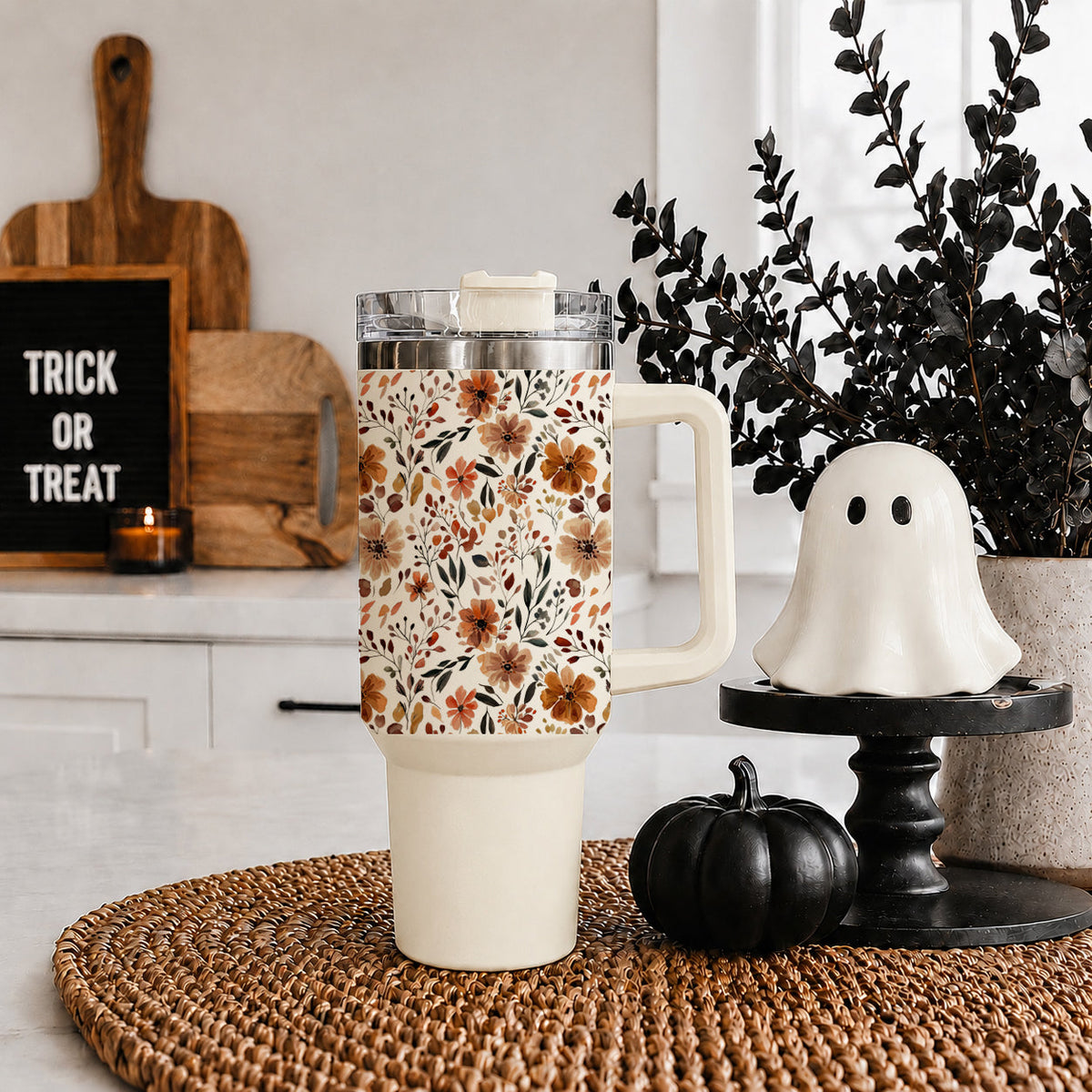 Floral 40oz tumbler with clear lid and straw, standing on a woven mat