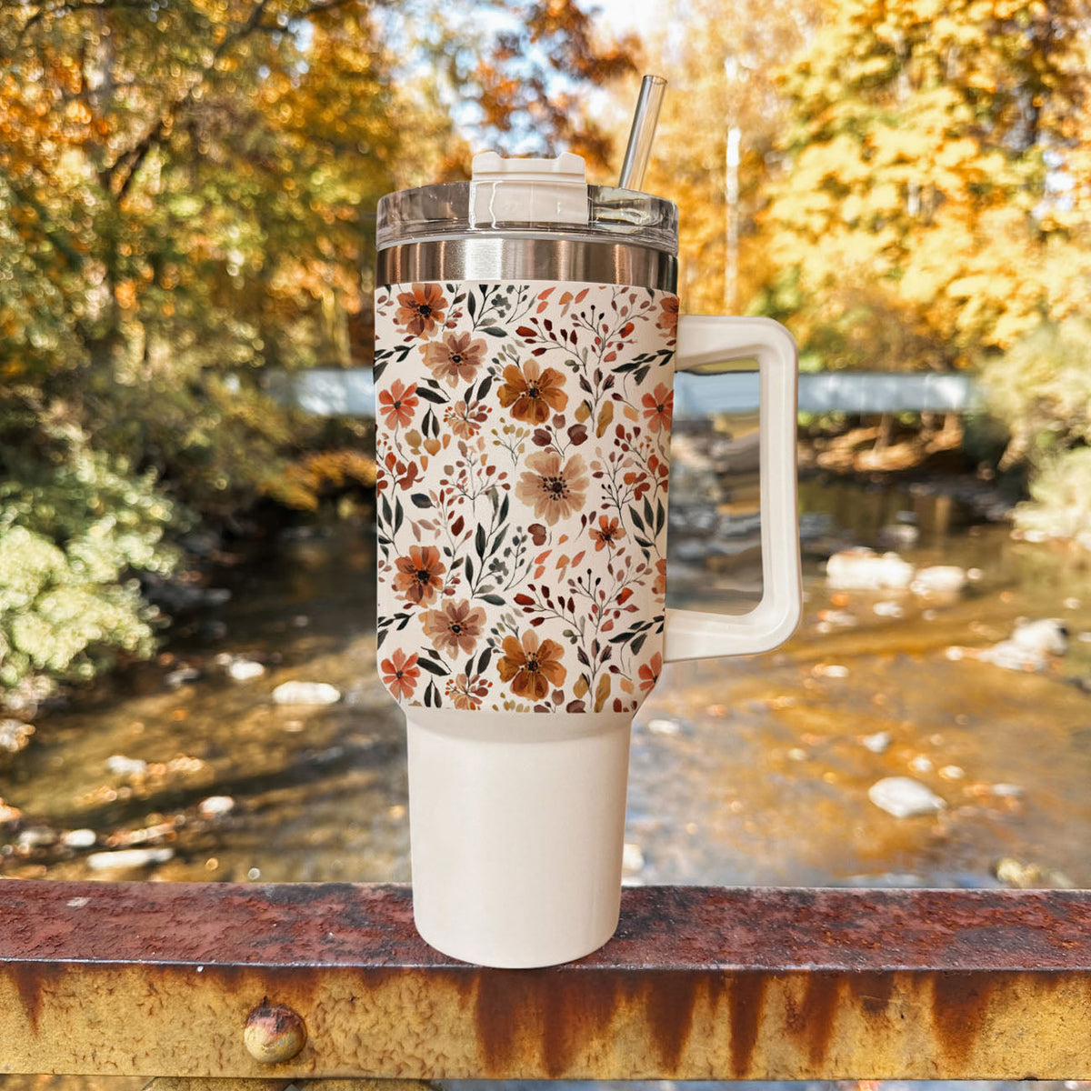 40oz floral insulated tumbler with clear lid and straw, outdoors on stone surface